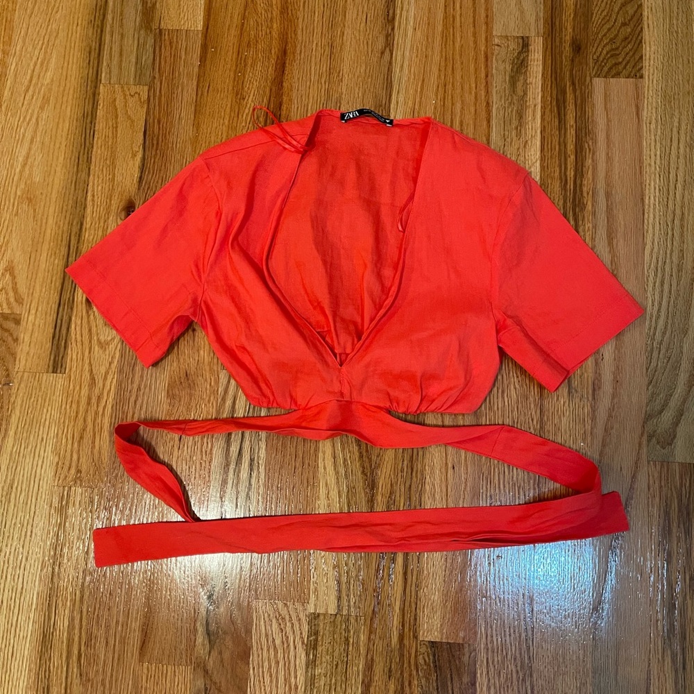 Red tie around cropped shirt
